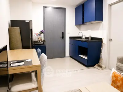 Modern apartment interior with blue kitchen cabinets and cozy dining area
