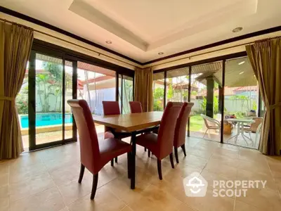 Spacious dining area with pool view and elegant decor in luxury home.