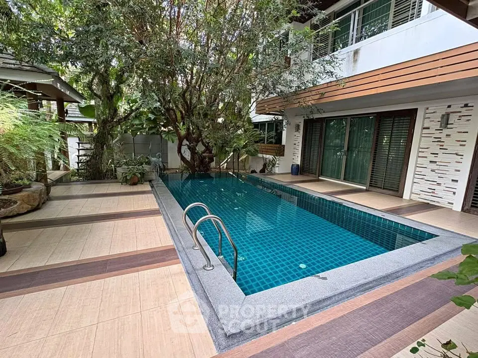 Stunning private pool surrounded by lush greenery in a modern residential property.