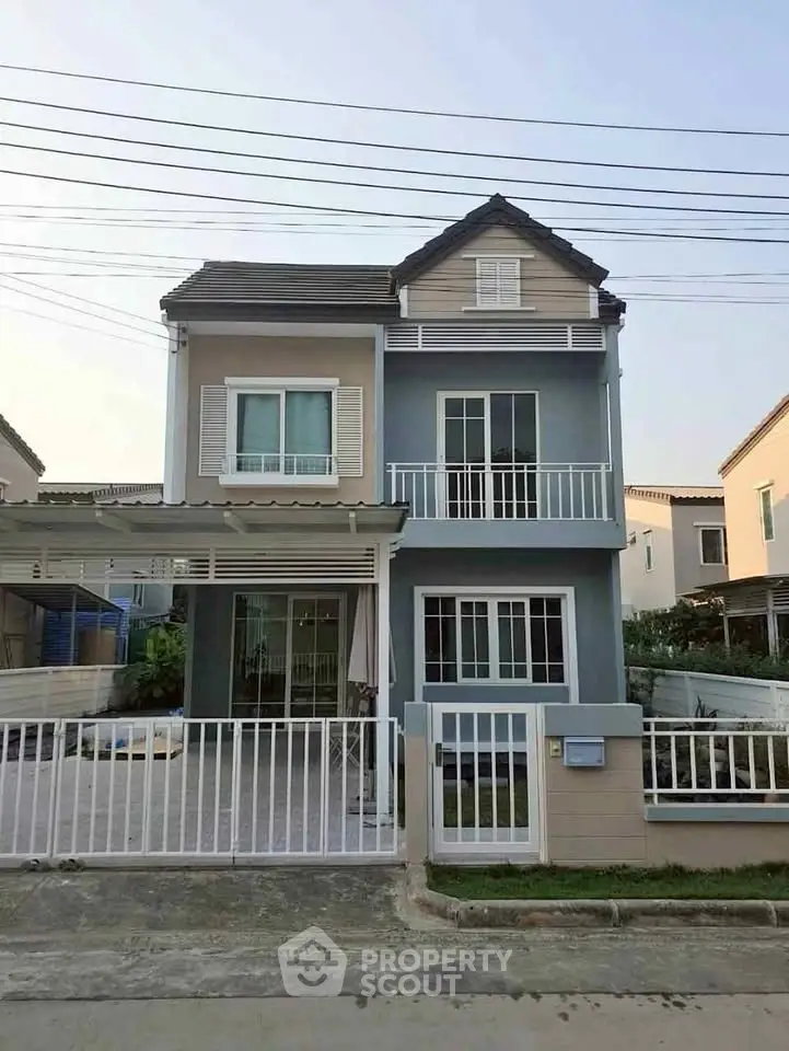 Charming two-story house with modern facade and spacious balcony in a serene neighborhood.