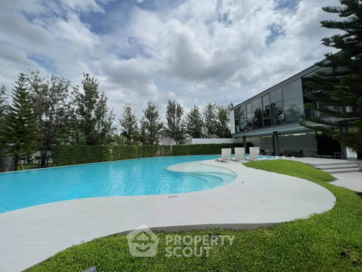 Luxurious modern home with stunning pool and lush greenery, perfect for relaxation and entertainment.