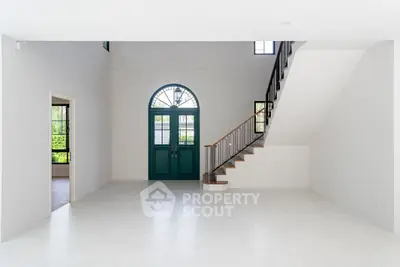 Spacious modern living room with high ceilings and elegant staircase