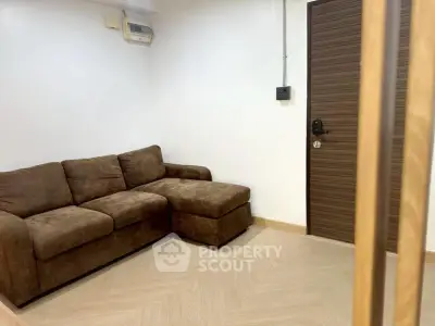 Cozy living room with brown sectional sofa and modern wooden door