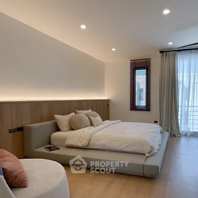 Luxurious modern bedroom with elegant lighting and large windows for natural light.