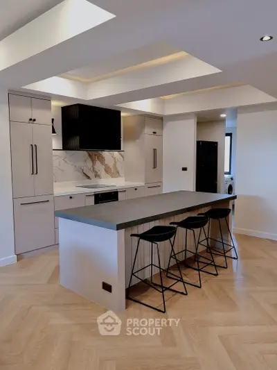 Modern kitchen with sleek island and stylish bar stools in contemporary apartment