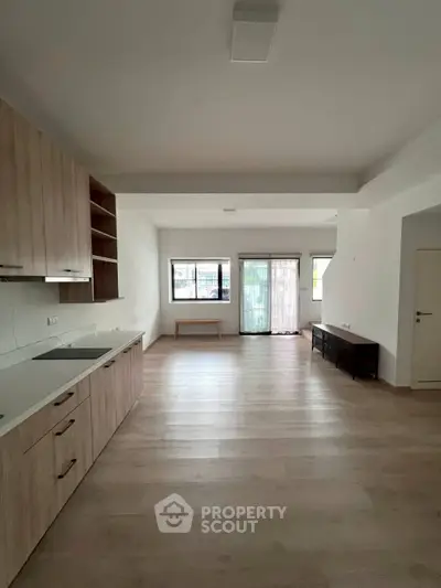 Spacious open-plan living room with modern kitchen and large windows