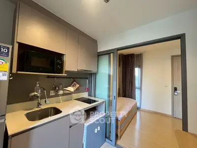 Modern compact kitchen with open layout and adjacent cozy bedroom