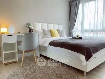 Modern bedroom with stylish decor and natural light, featuring a cozy bed and elegant furnishings.
