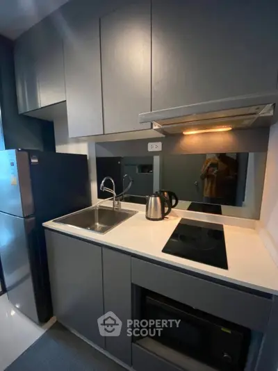 Modern compact kitchen with sleek cabinetry and built-in appliances, perfect for urban living.