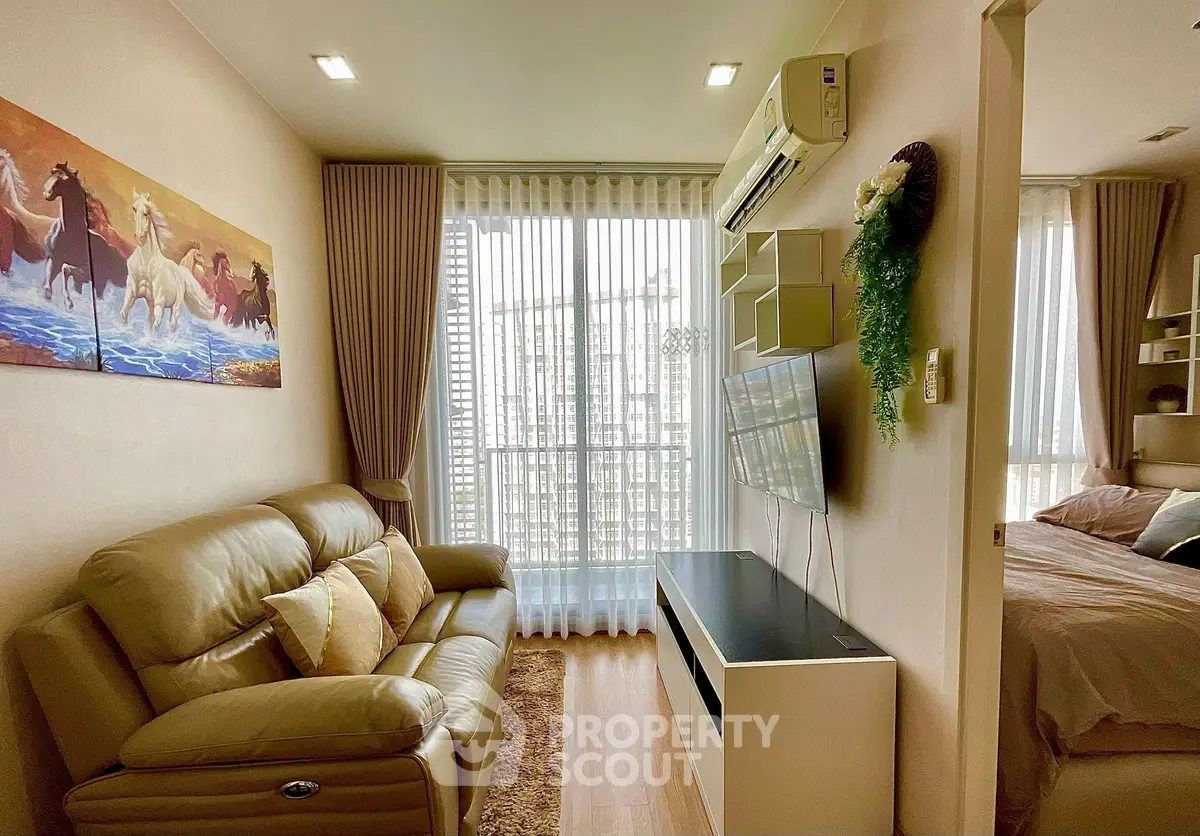 Cozy living room with modern decor and natural light, featuring a comfortable sofa and wall-mounted TV.