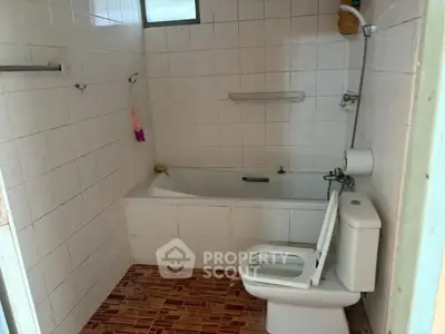 Cozy bathroom with bathtub and tiled walls, perfect for relaxation.