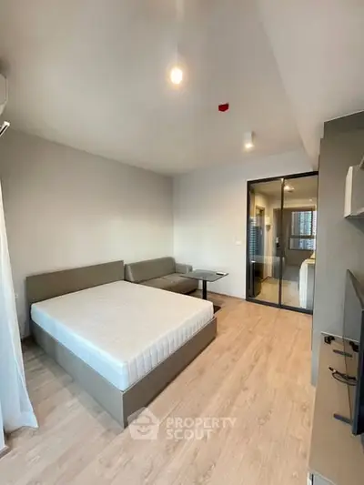 Modern bedroom with minimalist design and large window for natural light.