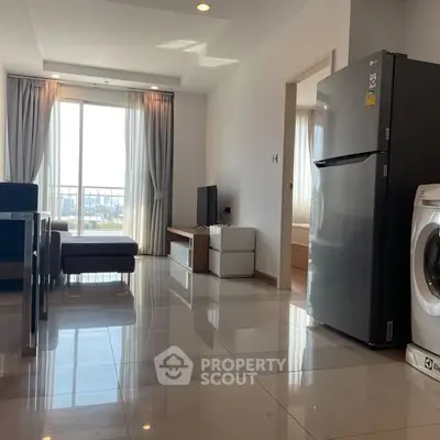 Modern living room with sleek furniture and appliances, featuring a large window with a city view.