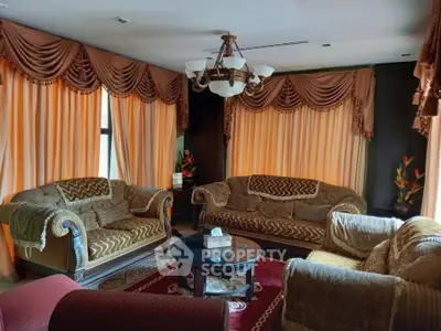 Luxurious living room with elegant drapery and plush seating, perfect for relaxation and entertaining.