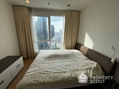 Spacious bedroom with large window offering stunning city view in modern apartment