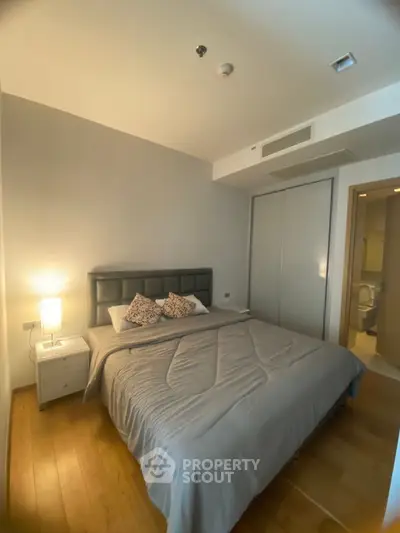 Cozy bedroom with modern decor and ensuite bathroom in a stylish apartment.