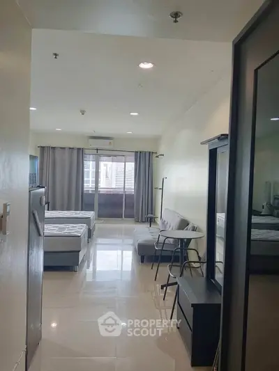 Spacious studio apartment with modern furnishings and large windows for natural light.