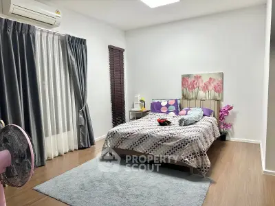 Spacious bedroom with modern decor and natural light, featuring a cozy bed and stylish curtains.