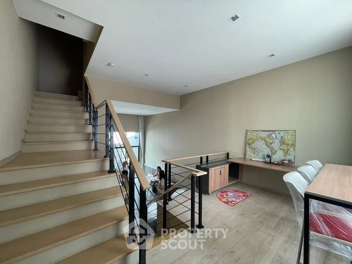 Spacious modern living area with staircase and dining table, perfect for family gatherings.