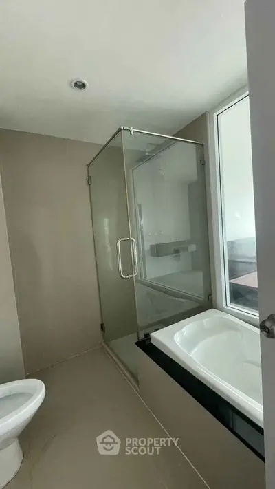 Modern bathroom with glass shower and bathtub in sleek design