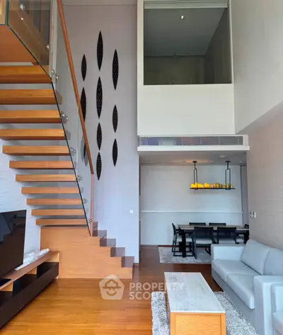 Modern duplex living room with wooden staircase and stylish dining area