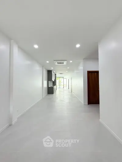 Spacious open-plan interior with modern lighting and sleek design, perfect for versatile living or office space.