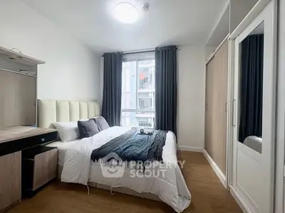 Modern bedroom with stylish decor and ample natural light in urban apartment.