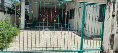 Charming gated entrance with decorative metalwork and spacious tiled driveway.