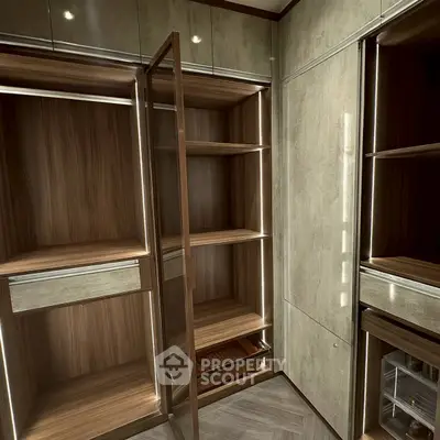Luxurious walk-in closet with elegant wooden shelves and modern lighting