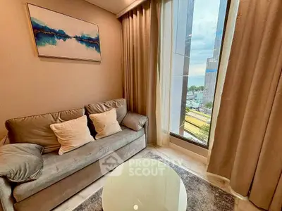 Cozy living room with modern decor and large window offering city view.