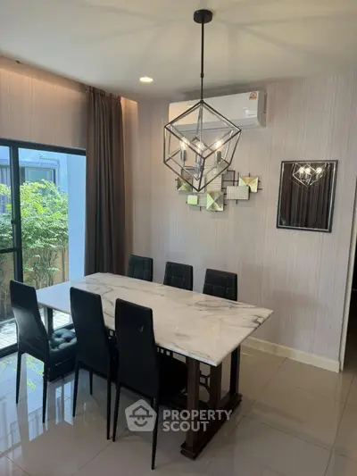 Elegant dining area with modern chandelier and marble table, perfect for stylish gatherings.