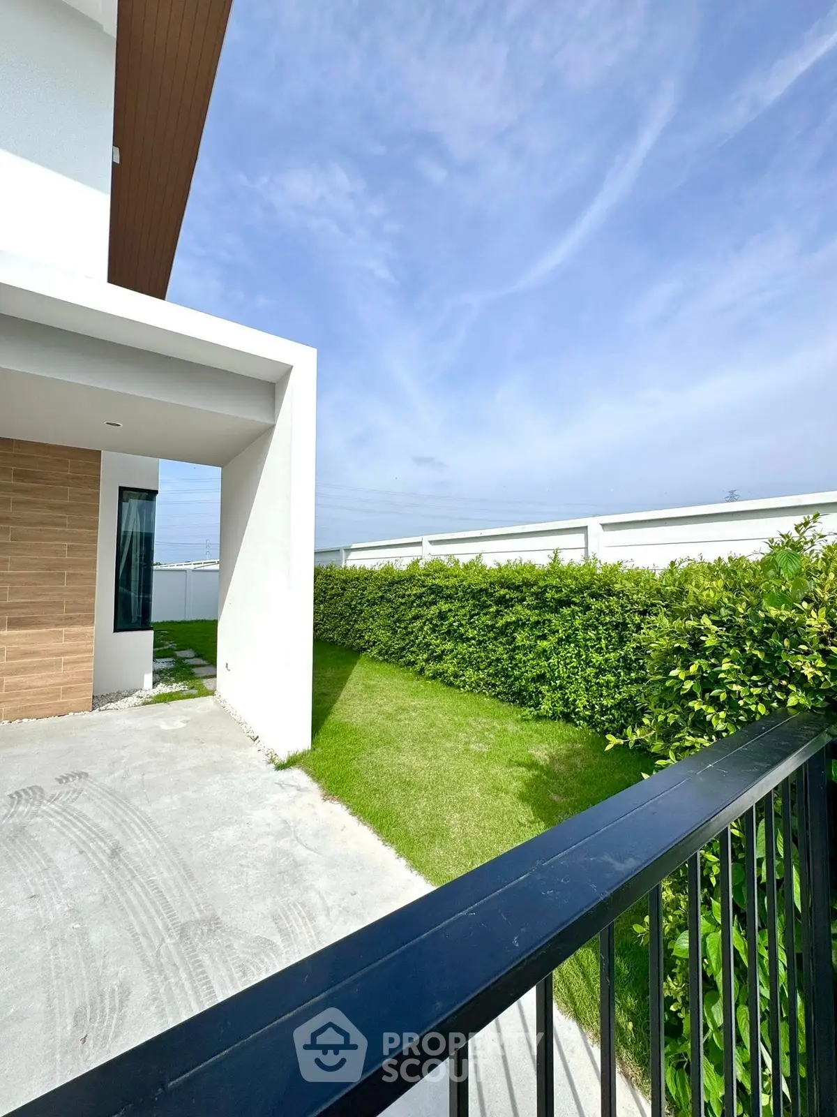 Modern house exterior with lush green garden and sleek design