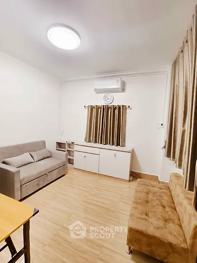 Cozy living room with modern furniture and air conditioning, perfect for relaxation.