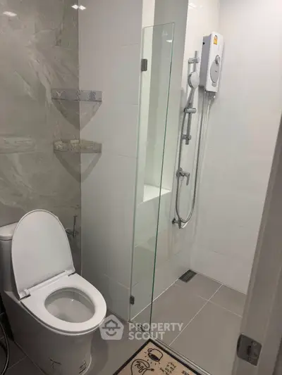 Modern bathroom with sleek shower and toilet design, featuring elegant marble wall accents.