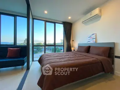 Modern bedroom with large windows and scenic view, featuring a comfortable bed and air conditioning.