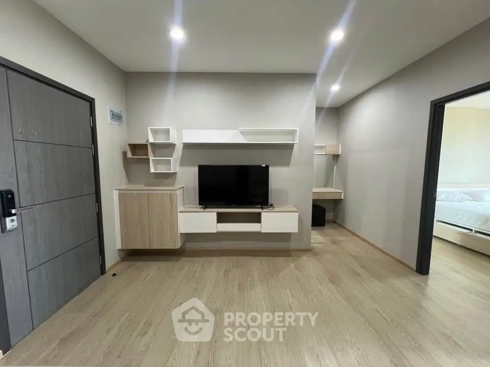 Modern living room with sleek TV unit and wooden flooring in stylish apartment