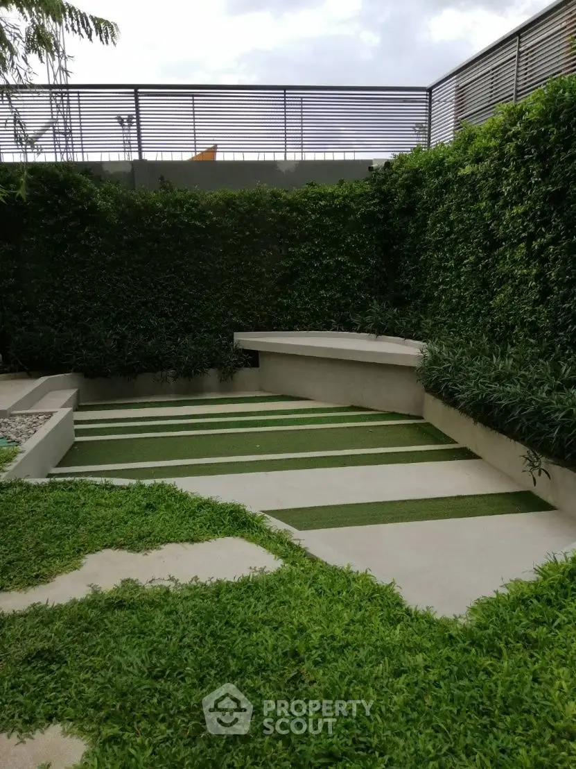 Modern garden with lush greenery and sleek concrete steps in a stylish outdoor space.