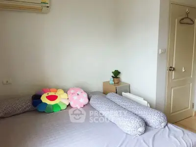 Cozy bedroom with plush pillows and minimalist decor, perfect for relaxation.