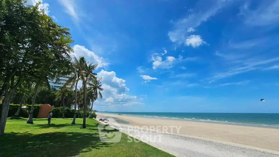 Stunning beachfront property with lush greenery and clear blue skies.