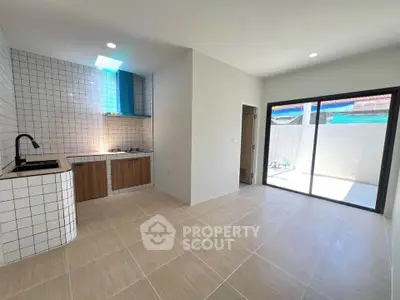 Modern kitchen with open layout and sleek design, featuring tiled walls and ample natural light.