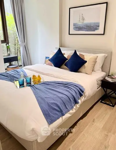 Cozy bedroom with elegant decor and natural light, featuring a comfortable bed and stylish artwork.