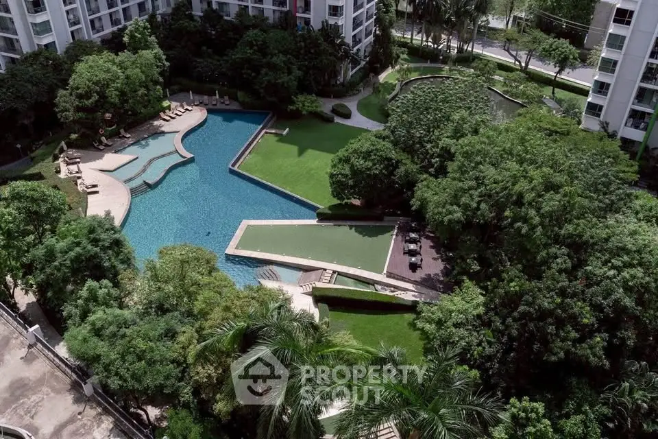Luxurious residential complex with stunning pool and lush garden views.