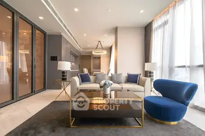 Luxurious modern living room with elegant furniture and large windows offering ample natural light.