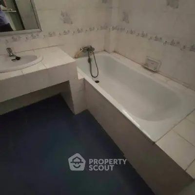 Cozy bathroom with bathtub and tiled walls, perfect for relaxation.