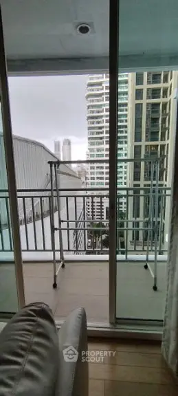 Modern apartment balcony with city view and glass railing