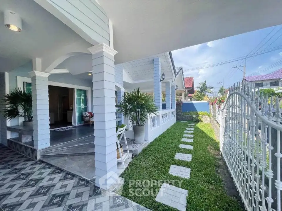 Charming house exterior with covered porch and lush garden pathway