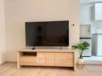 Modern living room with sleek TV stand and open kitchen layout, perfect for contemporary living.