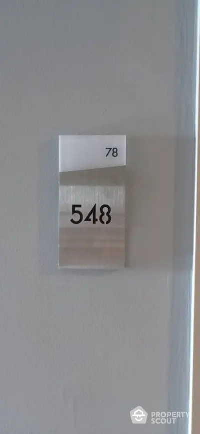 Modern apartment door number 548 on sleek metallic plaque