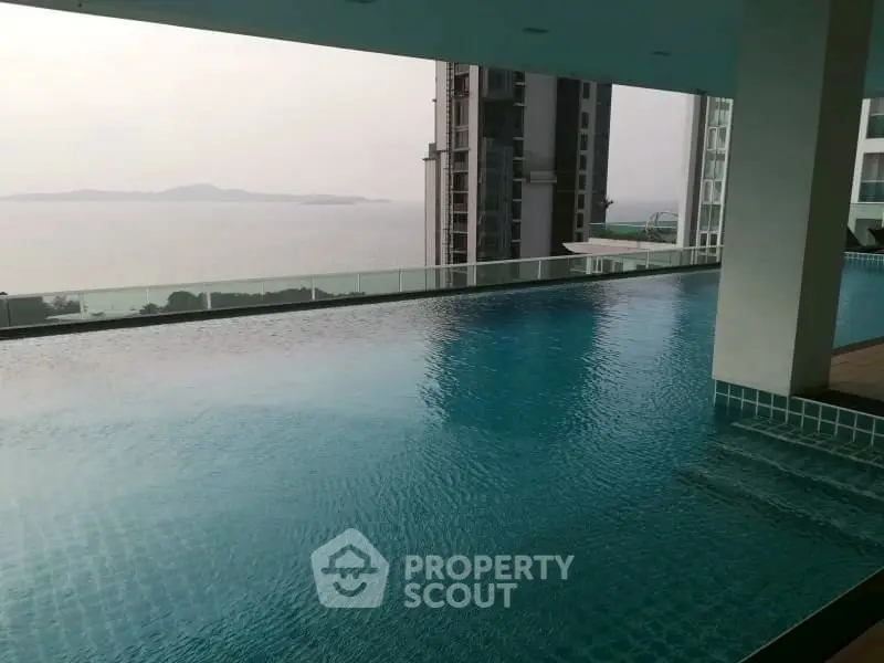 Luxurious rooftop infinity pool with stunning ocean view in modern high-rise building.