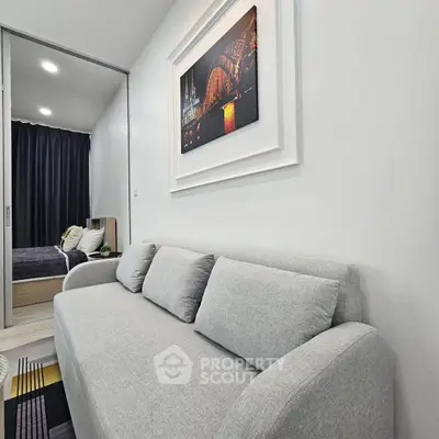 Modern living room with gray sofa and stylish wall art in a cozy apartment.
